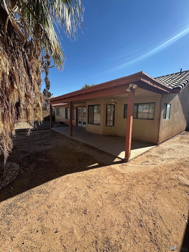 rear view of property featuring a patio, stucco siding, and french doors