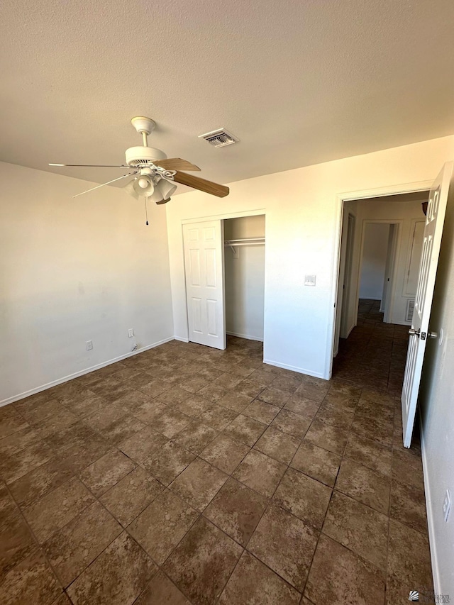 unfurnished bedroom featuring baseboards, a closet, a textured ceiling, and visible vents
