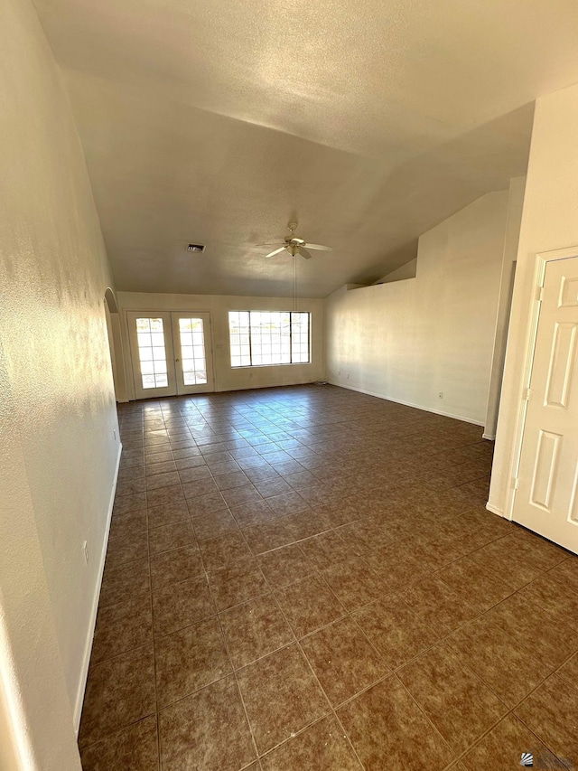 spare room with ceiling fan, a textured ceiling, visible vents, lofted ceiling, and a textured wall