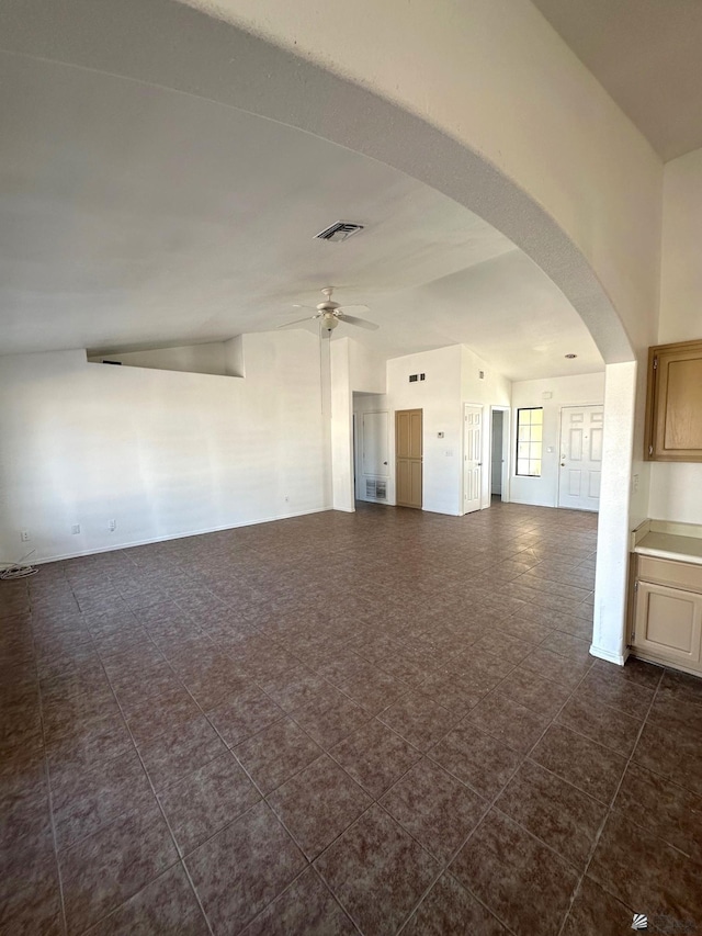 unfurnished room featuring visible vents, a ceiling fan, and arched walkways