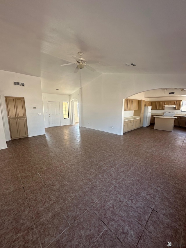 unfurnished living room featuring dark tile patterned flooring, ceiling fan, lofted ceiling, and visible vents