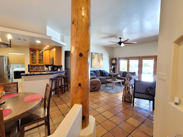 living room with visible vents, a ceiling fan, and light tile patterned flooring