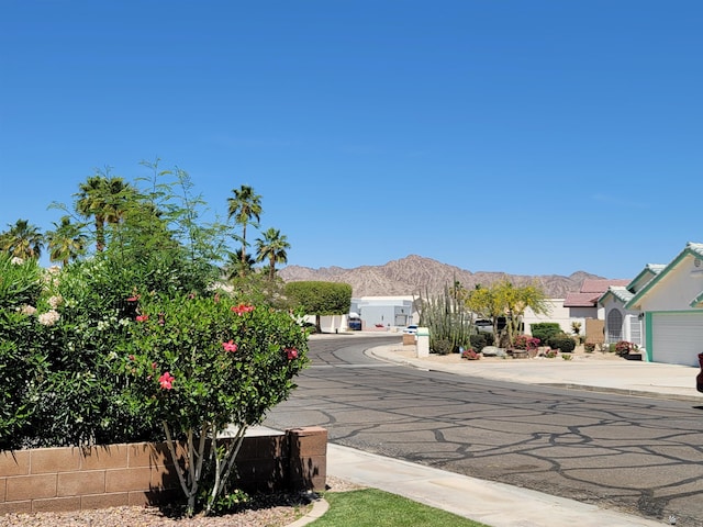 view of road with a mountain view and curbs