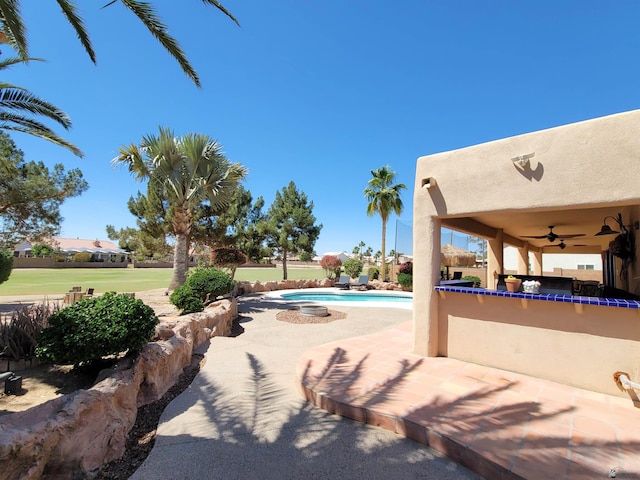 view of pool featuring a fenced in pool, ceiling fan, and a patio area