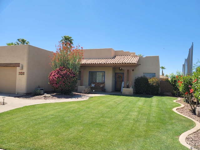 pueblo-style home with a front yard and stucco siding