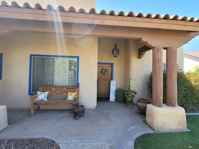 property entrance featuring a patio and stucco siding
