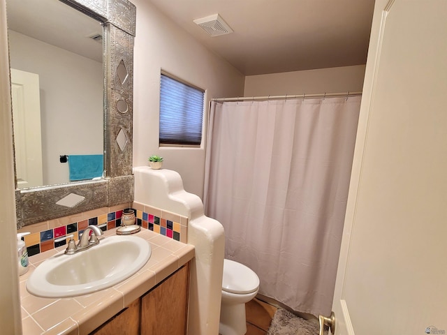 bathroom featuring a shower with curtain, decorative backsplash, visible vents, vanity, and toilet