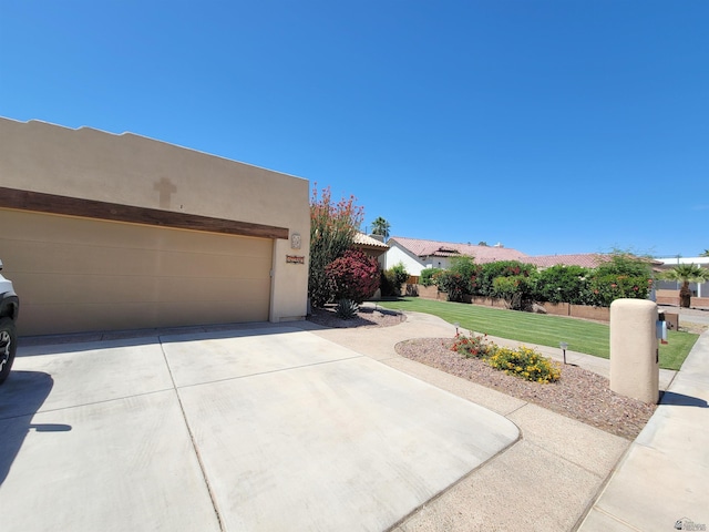 view of side of home featuring a lawn, driveway, and stucco siding