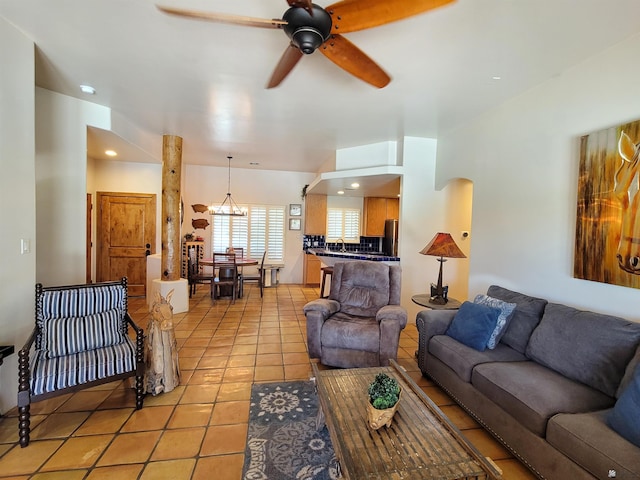 living area with light tile patterned floors, arched walkways, ceiling fan, and recessed lighting