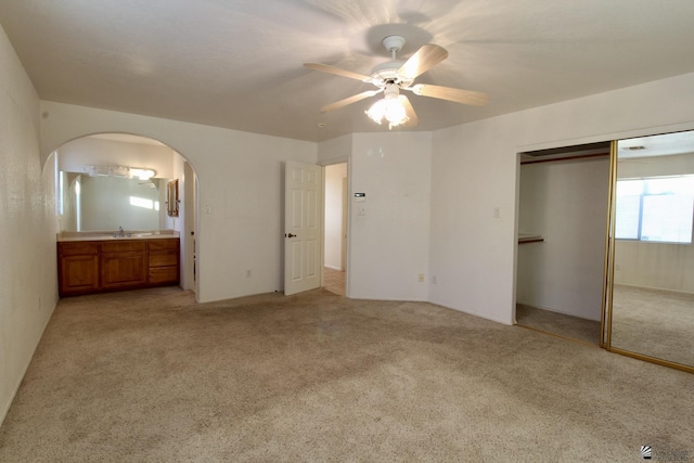 1565 W Vicky Ln, Yuma, AZ 85364 - unfurnished bedroom with light carpet, a sink, ensuite bath, arched walkways, and a closet