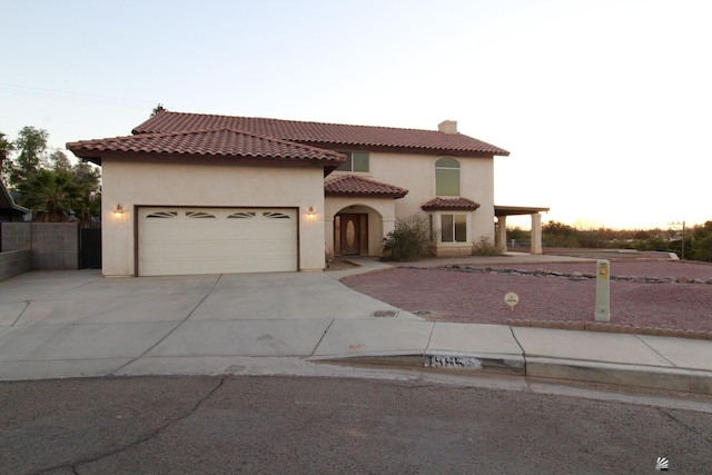 1565 W Vicky Ln, Yuma, AZ 85364 - mediterranean / spanish house featuring driveway, a chimney, a tile roof, a garage, and stucco siding