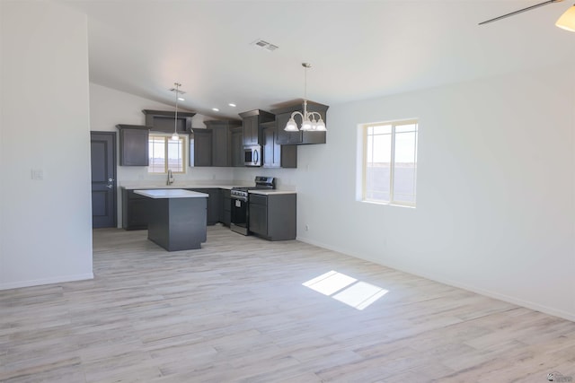 10858 E 45th St, Yuma, AZ 85367 - kitchen featuring appliances with stainless steel finishes, a chandelier, a kitchen island, vaulted ceiling, and light countertops