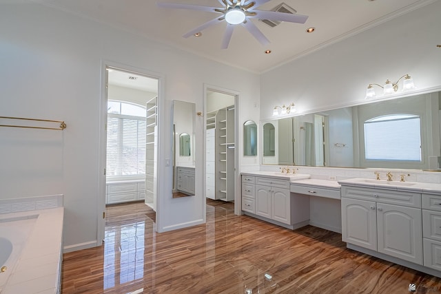 full bathroom with ceiling fan, wood finished floors, two vanities, a sink, and ornamental molding
