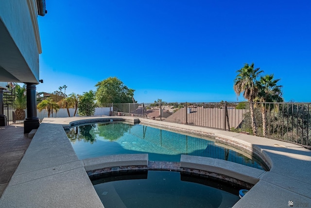 view of pool featuring a fenced backyard and a pool with connected hot tub