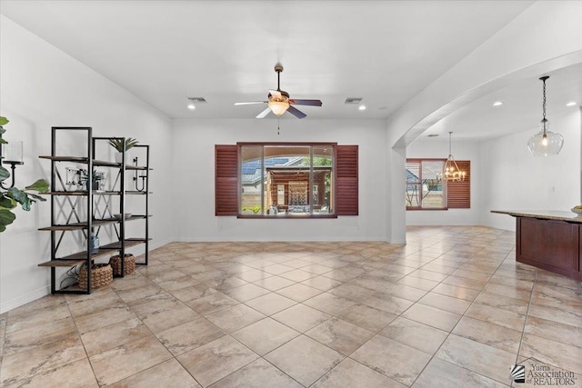 unfurnished living room featuring a chandelier, recessed lighting, arched walkways, a ceiling fan, and light tile patterned flooring