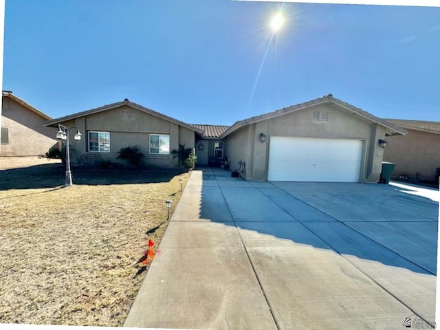 single story home with stucco siding, driveway, and a garage