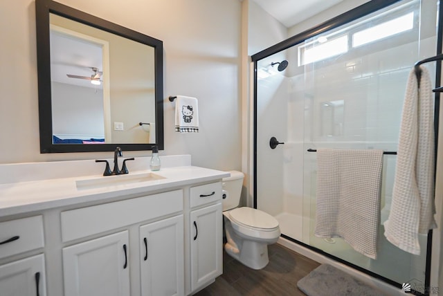 7563 E 35th Ln, Yuma, AZ 85365 - bathroom featuring toilet, vanity, a stall shower, wood finished floors, and ceiling fan