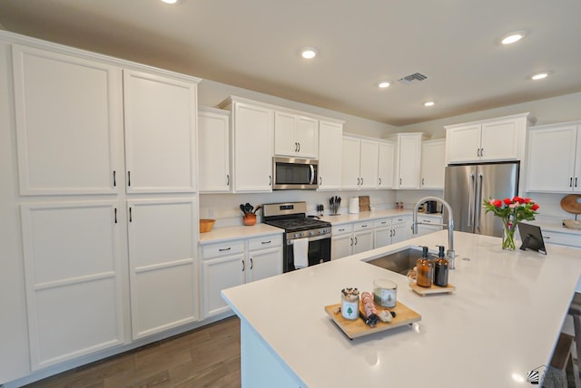 7563 E 35th Ln, Yuma, AZ 85365 - kitchen featuring stainless steel appliances, a sink, dark wood finished floors, white cabinets, and a center island with sink