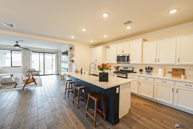 7563 E 35th Ln, Yuma, AZ 85365 - kitchen with appliances with stainless steel finishes, dark wood-style flooring, white cabinets, a kitchen bar, and open floor plan
