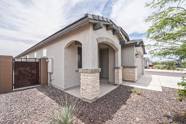 7563 E 35th Ln, Yuma, AZ 85365 - view of side of home with a gate, stucco siding, and stone siding
