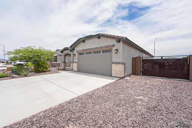 7563 E 35th Ln, Yuma, AZ 85365 - view of front of property with a garage, concrete driveway, stucco siding, a gate, and stone siding