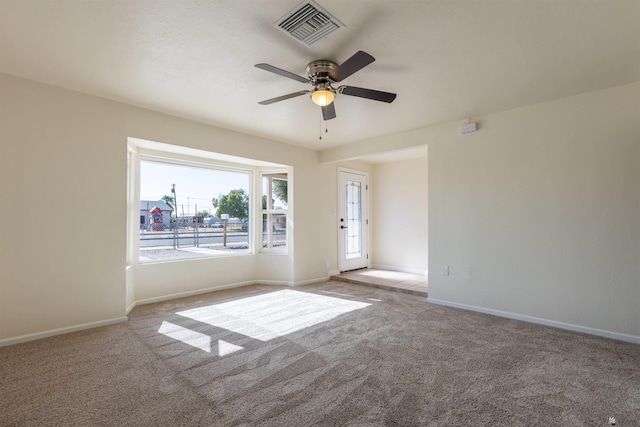 spare room with baseboards, ceiling fan, carpet flooring, and visible vents