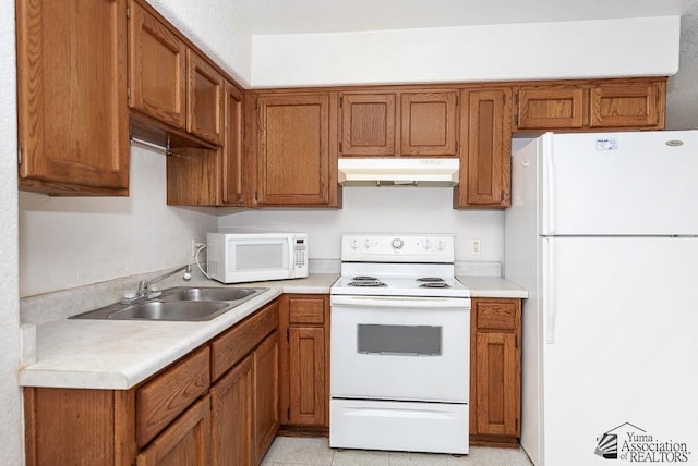 12614 E 45th Dr, Yuma, AZ 85367 - kitchen with a sink, under cabinet range hood, brown cabinets, and white appliances