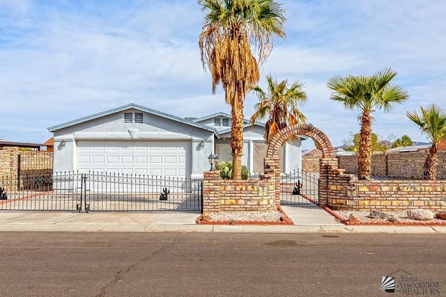 12614 E 45th Dr, Yuma, AZ 85367 - view of front of house featuring a fenced front yard, a gate, concrete driveway, an attached garage, and stucco siding