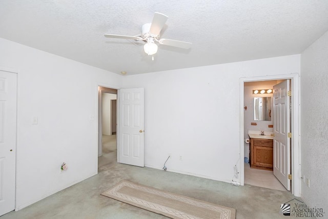 12614 E 45th Dr, Yuma, AZ 85367 - unfurnished bedroom featuring ceiling fan, light carpet, a sink, ensuite bath, and a textured ceiling
