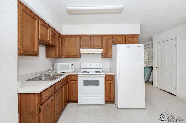 12614 E 45th Dr, Yuma, AZ 85367 - kitchen with brown cabinetry, a sink, under cabinet range hood, and white appliances