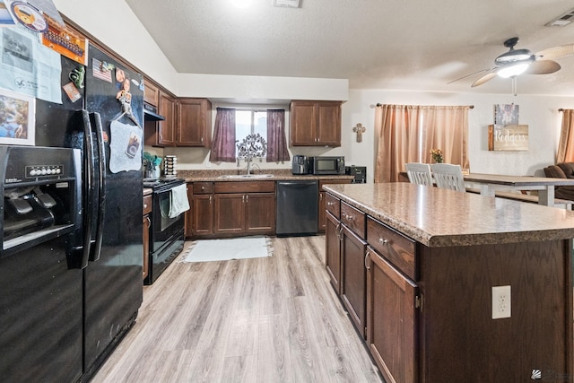 kitchen featuring ceiling fan, a sink, light wood-style flooring, visible vents, and black appliances