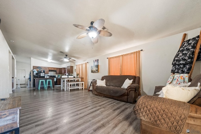 living room with dark wood-style flooring, ceiling fan, and vaulted ceiling
