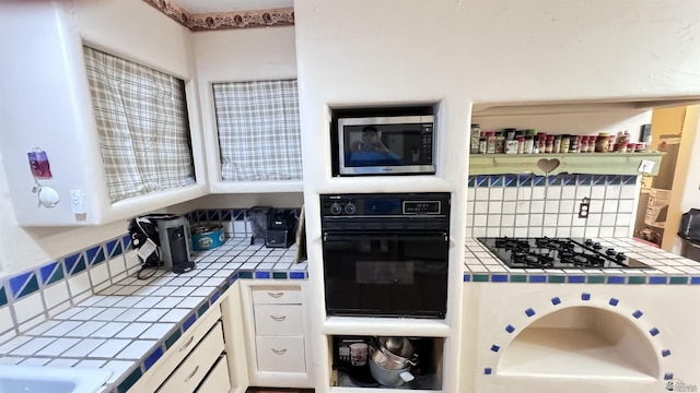 13725 E 46th St, Yuma, AZ 85367 - kitchen featuring tile counters, white cabinetry, backsplash, and black appliances