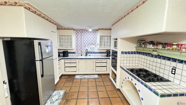 13725 E 46th St, Yuma, AZ 85367 - kitchen with a sink, tile counters, black appliances, and tasteful backsplash