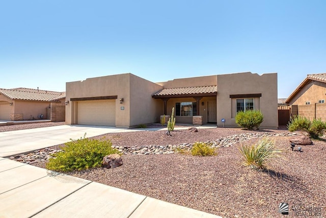 11561 E 25th Pl, Yuma, AZ 85367 - pueblo-style home with driveway, an attached garage, stucco siding, and a tiled roof