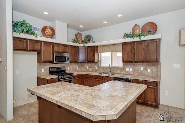11561 E 25th Pl, Yuma, AZ 85367 - kitchen featuring stainless steel appliances, backsplash, tile counters, a kitchen island, and recessed lighting