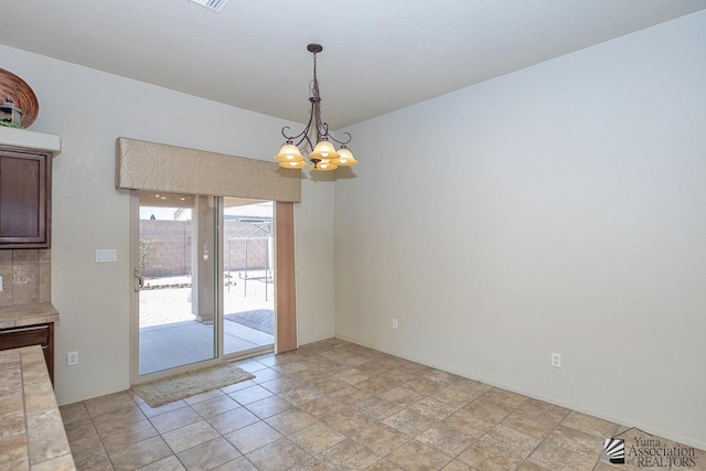 11561 E 25th Pl, Yuma, AZ 85367 - unfurnished dining area with a chandelier and light stone finish floors