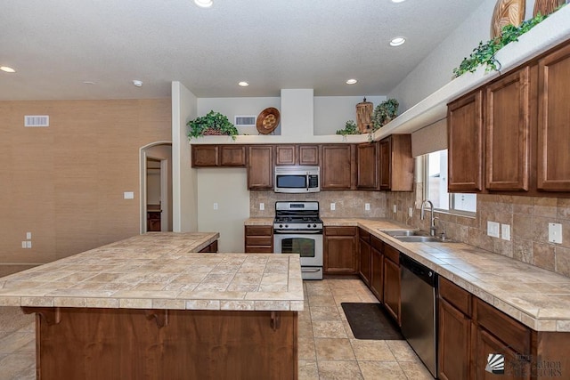 11561 E 25th Pl, Yuma, AZ 85367 - kitchen with appliances with stainless steel finishes, recessed lighting, backsplash, a kitchen island, and arched walkways