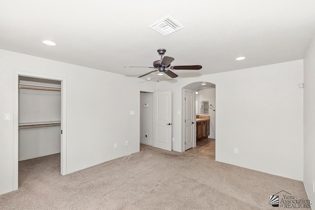 11561 E 25th Pl, Yuma, AZ 85367 - unfurnished bedroom with arched walkways, light colored carpet, a spacious closet, recessed lighting, and ensuite bathroom