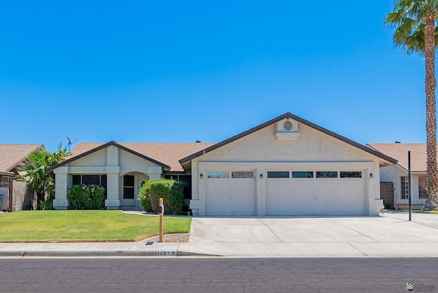 ranch-style home featuring an attached garage, concrete driveway, stucco siding, and a front lawn