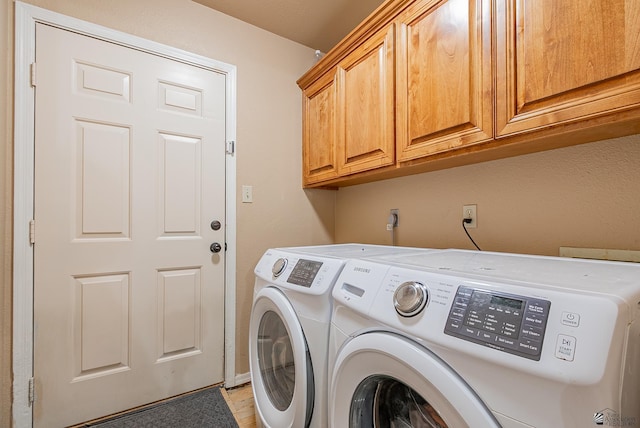 laundry area with independent washer and dryer and cabinet space