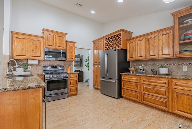 kitchen featuring stainless steel appliances, visible vents, a sink, and tasteful backsplash