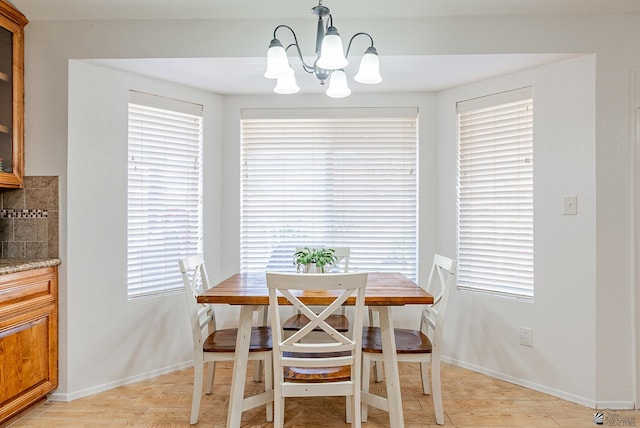 dining room featuring baseboards, an inviting chandelier, and light wood-style flooring