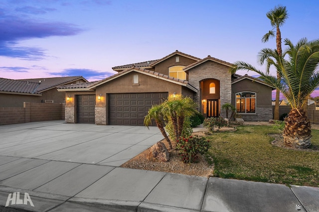 7846 E 37th Pl, Yuma, AZ 85365 - view of front of house featuring a garage, stucco siding, a tile roof, and stone siding