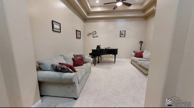 carpeted living room with a ceiling fan, baseboards, recessed lighting, and a raised ceiling