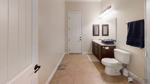 bathroom with vanity, baseboards, tile patterned floors, and toilet