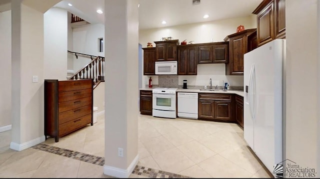 kitchen with a sink, white appliances, light countertops, recessed lighting, and light tile patterned floors