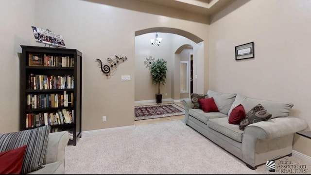 living room featuring carpet flooring, arched walkways, and baseboards