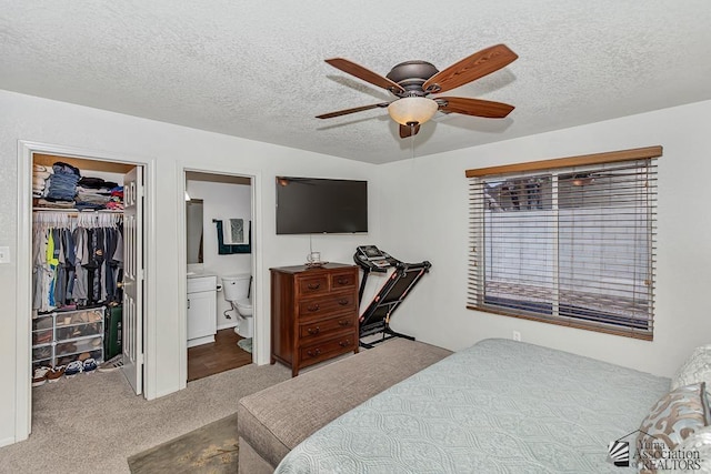 4452 S Agave Ave, Yuma, AZ 85365 - carpeted bedroom featuring a walk in closet, a textured ceiling, ensuite bathroom, and a ceiling fan
