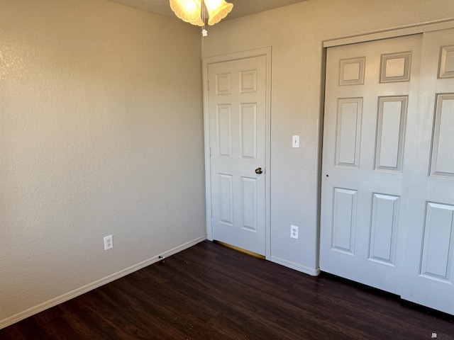 11278 E 24th Pl, Yuma, AZ 85367 - unfurnished bedroom with a closet, baseboards, and dark wood-type flooring